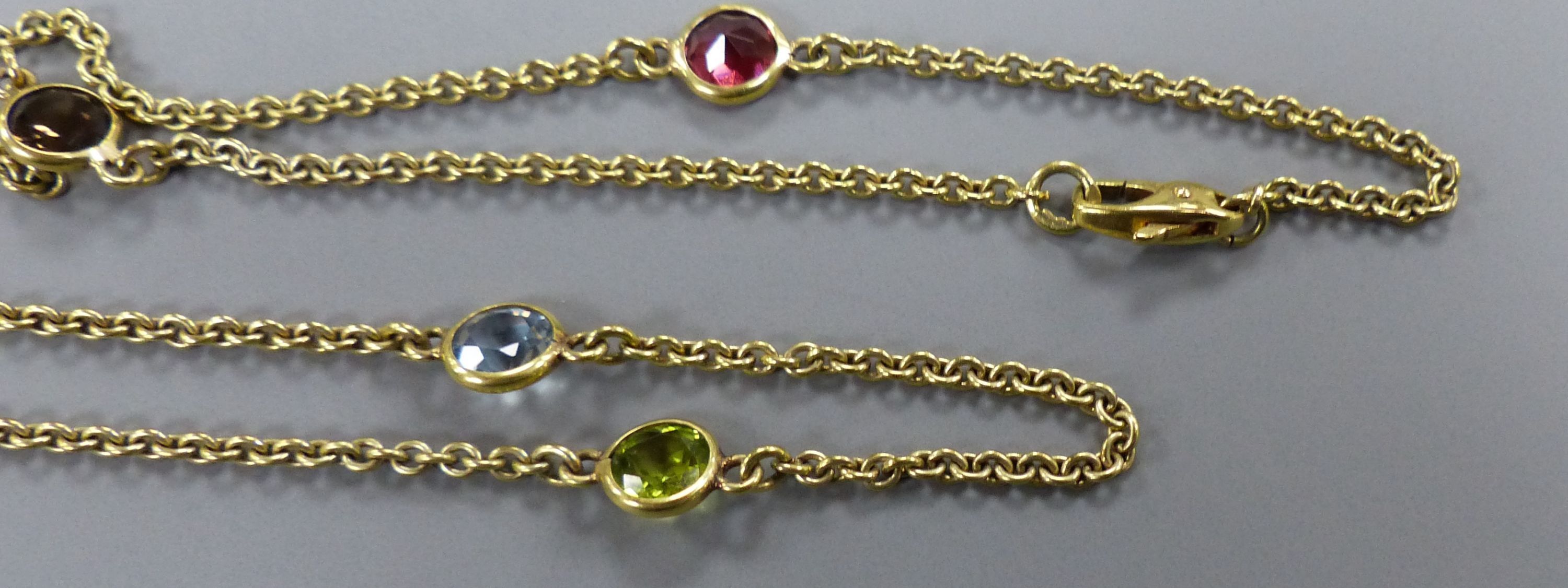 A modern 9ct gold and eight stone multi-gem set 'spectacle' necklace, 60cm, gross 9 grams.